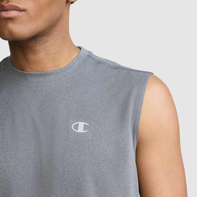 A person is shown from the shoulders up against a plain light background, wearing the Champion Sport Muscle Tank with a reflective C logo on the chest. This men’s muscle tank is made with moisture-wicking fabric to help keep you comfortable during any workout.