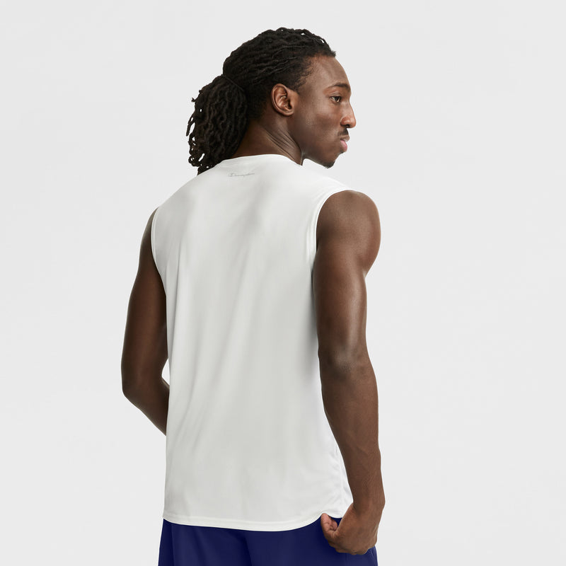 A man with long, braided hair stands facing away in a Champion Sport Muscle Tank with a Reflective C Logo and blue shorts against a plain white background.