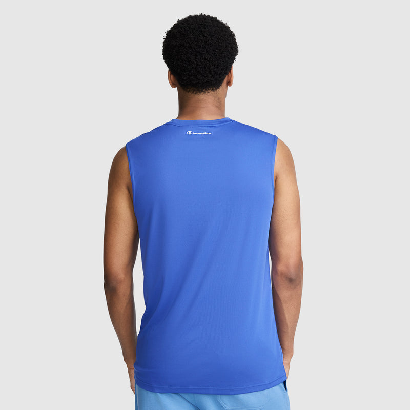 A man stands facing away, wearing a blue Champion Sport Muscle Tank with a reflective C logo—recognized for its moisture-wicking fabric—and light blue shorts, set against a plain light gray background.