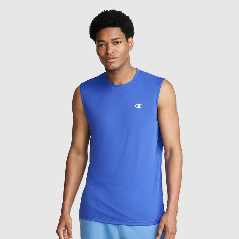 A man stands against a plain gray background, looking at the camera with a slight smile, wearing the Champion Sport Muscle Tank with a reflective C logo on the chest.
