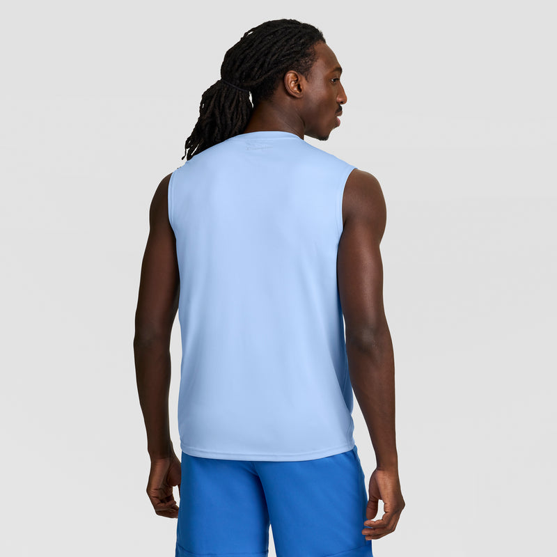 A man with long, dark dreadlocks is shown from the back wearing Champion’s Sport Muscle Tank with a Reflective C Logo and blue shorts, standing against a plain light gray background.