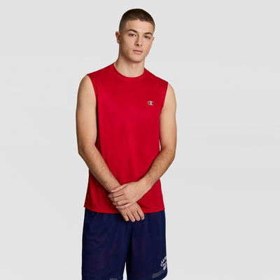 A young man with short hair wears the Champion Sport Muscle Tank with a Reflective C Logo, paired with navy blue shorts, standing against a plain light gray background with his hands clasped in front of him.
