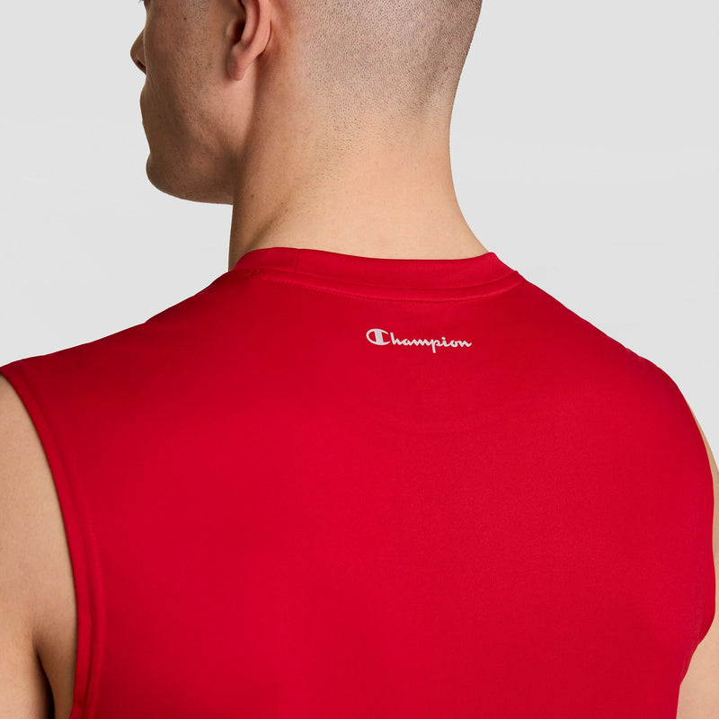 A person is seen from the back wearing the Champion Sport Muscle Tank with a reflective C logo near the neck. The sleeveless tank is red, and the background is plain and light-colored.
