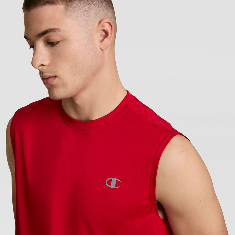 A young man with short hair wears the Champion Sport Muscle Tank featuring a reflective C logo, looking down against a plain light gray background.