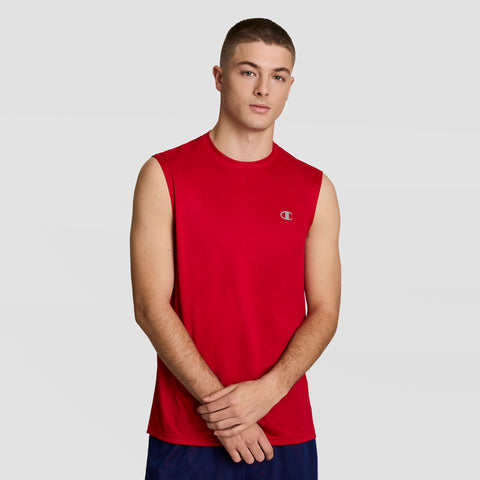 A young man with short hair wears the Champion Sport Muscle Tank with a Reflective C Logo and dark athletic shorts, standing against a plain light gray background with his hands loosely clasped in front of him.