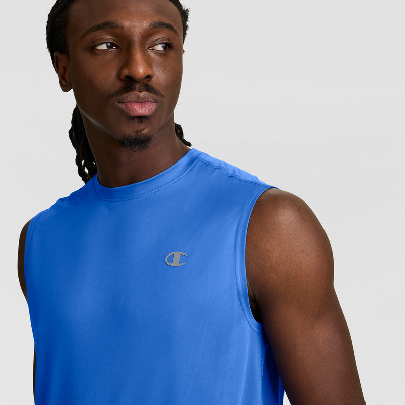 A man with long hair wears the Champion Sport Muscle Tank featuring a reflective C logo on the chest, posing slightly to the side against a plain light background.
