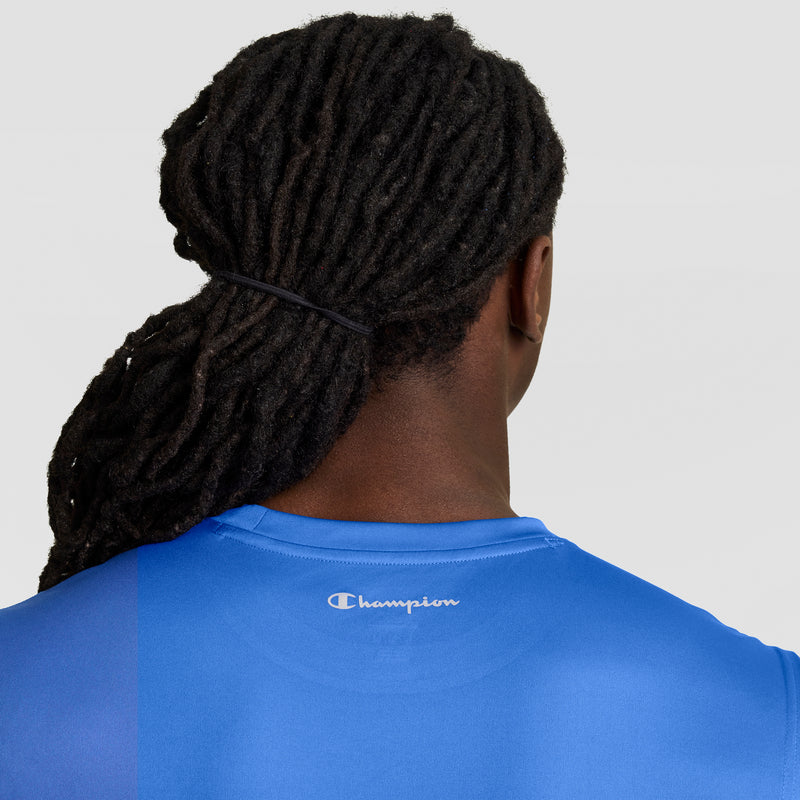 A person with long, dark dreadlocks tied back is seen from behind wearing the Champion Sport Muscle Tank with a Reflective C Logo against a plain, light background.