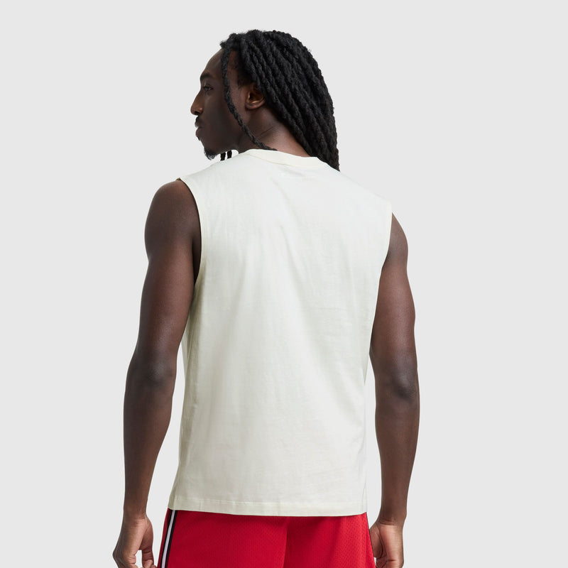 A person with long, dark braided hair is seen from the back, wearing a Champion Muscle Tank, C Logo and red shorts with white side stripes, standing against a plain light gray background.
