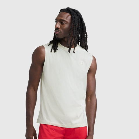 A man with long dreadlocks models the Champion Muscle Tank, C Logo, paired with red shorts, against a plain light gray background while looking to his left.