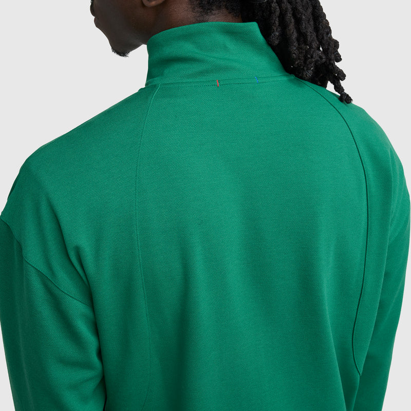 A person with long, dark hair is seen from behind, wearing a bright green Champion Gameday Full Zip Mock Neck, C Logo jacket against a plain light background.