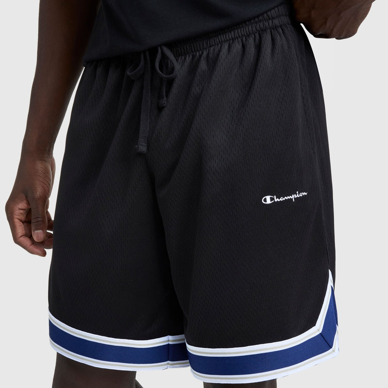 A person wears Champion 10" Gridiron Reversible Shorts with the script logo on the left leg and white and blue stripes near the hem. The mesh fabric provides comfort, and their hand rests at their side.