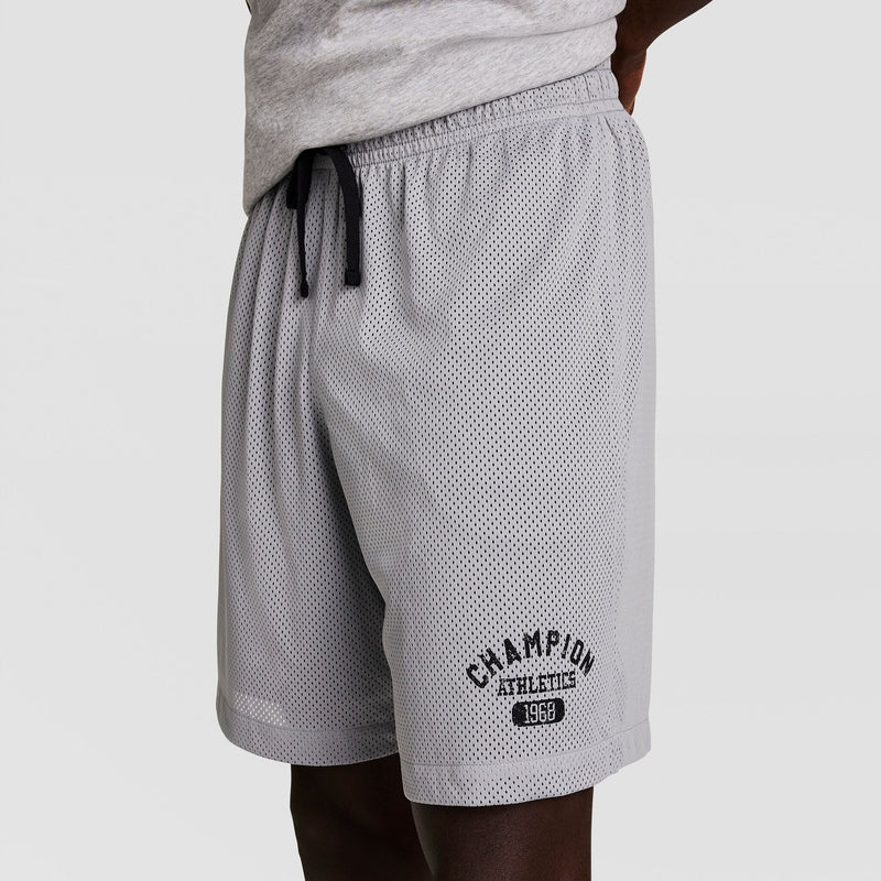 A person wearing light gray mesh athletic shorts with a black drawstring and Champion Athletic 1969 logo on the left leg. The person is also wearing a light gray t-shirt. Only the lower torso and upper legs are visible.