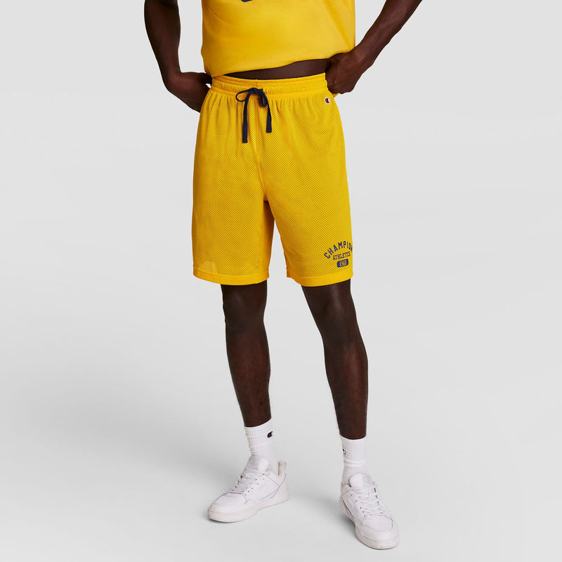 A person wears a yellow T-shirt, yellow Champion athletic shorts with a blue drawstring, white socks, white sneakers, and a Champion Powerblend Full-Zip Hoodie (C Logo - Big & Tall), standing on a white background. Their face is not visible.