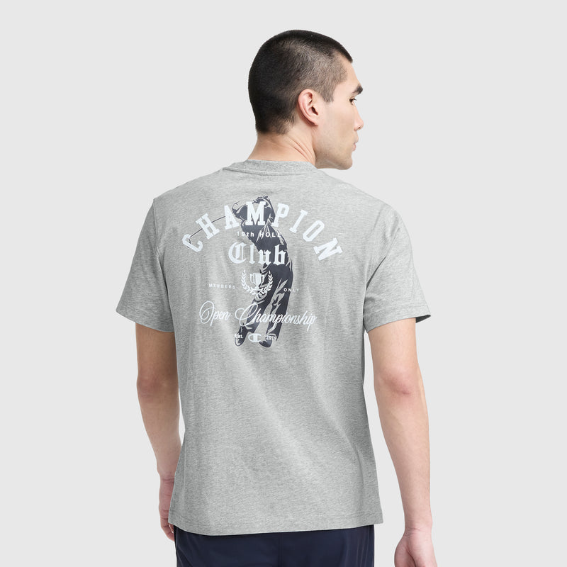 A man with short dark hair, facing away, wears a Champion Club Graphic T-Shirt by Champion, made from soft cotton jersey with white "CHAMPION Club" and "Open Championship" text and graphic on the back.