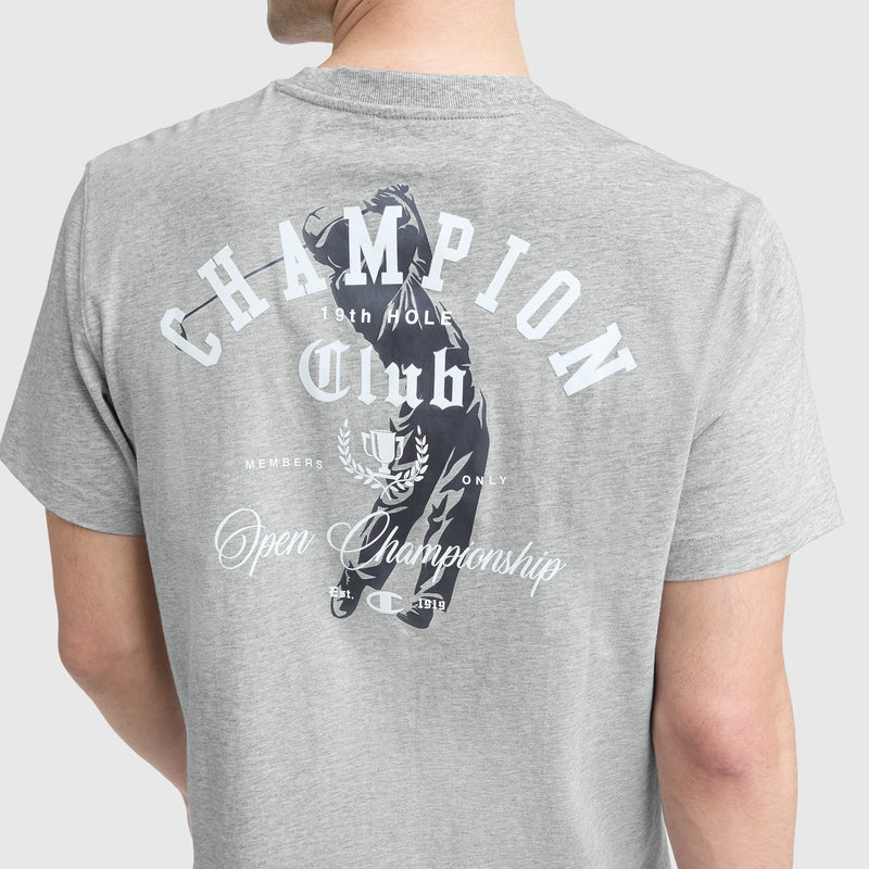 Someone wearing a Champion Club Graphic T-Shirt by Champion, in light gray cotton jersey, with the C logo and white back text: "CHAMPION Club 18th Hole Members Only Open Championship" and a golfer swinging a club.