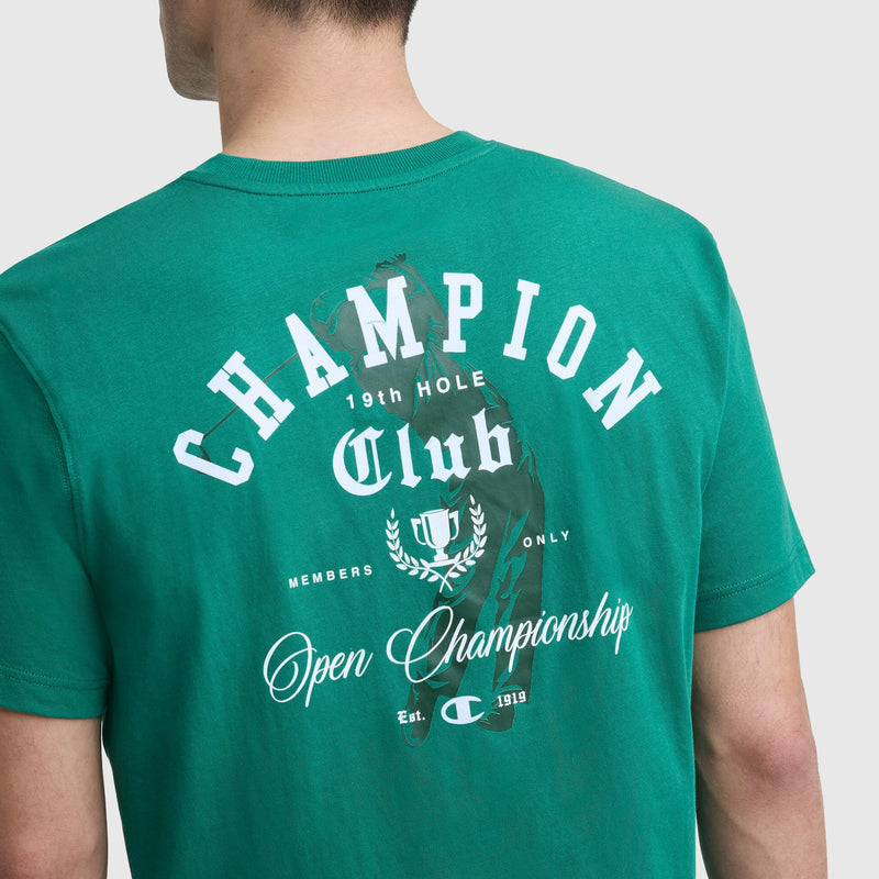 A person wears the Champion Club Graphic T-Shirt by Champion, featuring golf-inspired style and back text: "Champion Club 19th Hole, Members Only, Open Championships, Est. 1919," with a laurel wreath and small C logo.