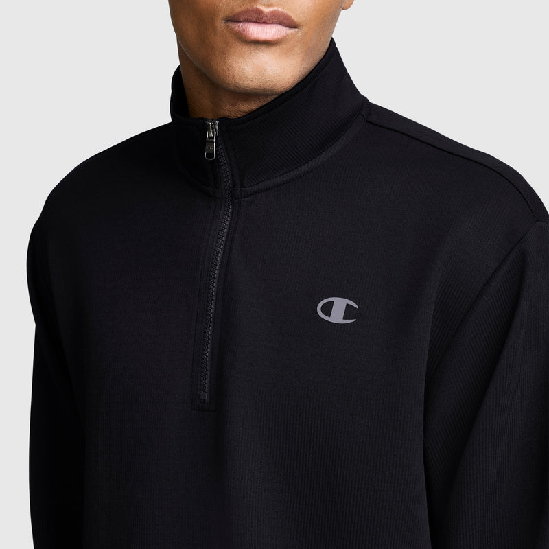 A person shown from the shoulders up against a plain background is wearing the Champion Sport Long Sleeve 1/4 Zip Mockneck, C Logo in black, featuring a small Champion logo on the chest.