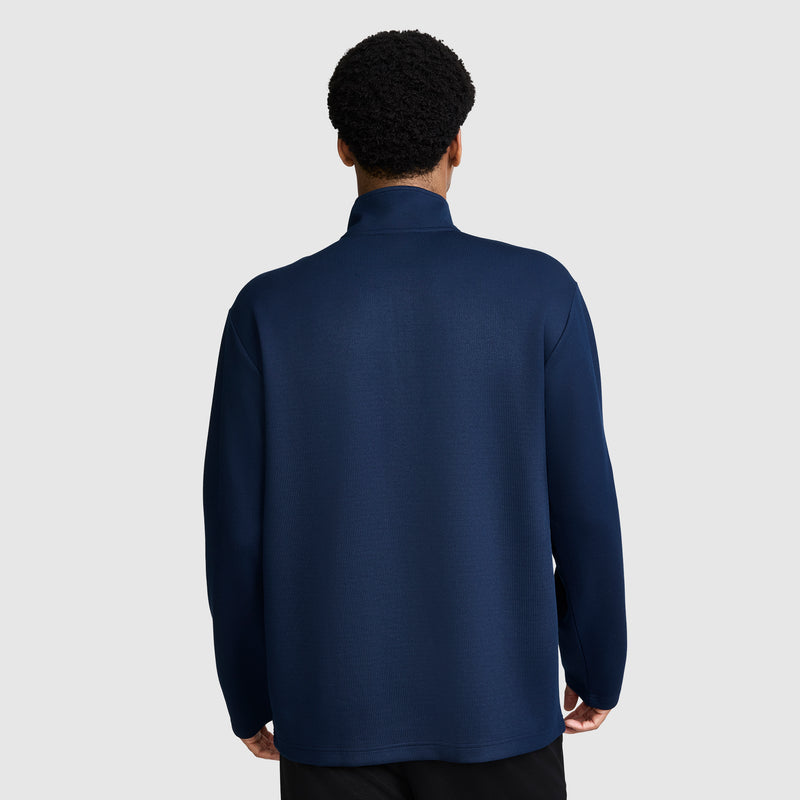 A person with short curly hair is shown from behind, wearing the Champion Sport Long Sleeve 1/4 Zip Mockneck with C Logo in dark blue against a plain light gray background.