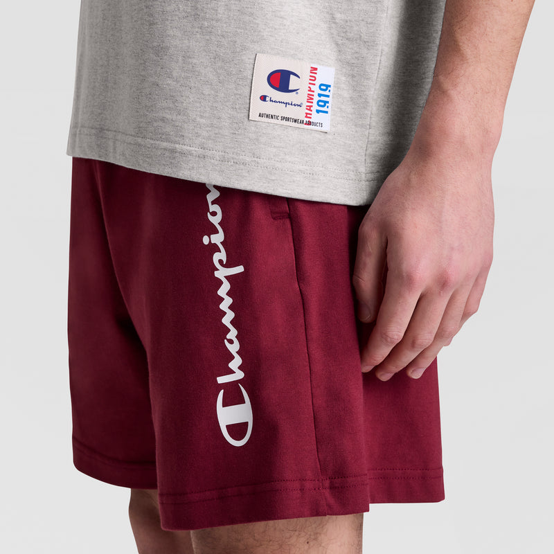 A person wearing a Champion Sleeveless Hoodie with an embroidered C logo is shown from the lower torso and right arm against a plain background.