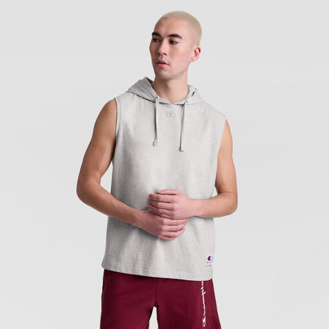 A person with short blond hair wears a Champion Sleeveless Hoodie with an embroidered C logo and maroon athletic shorts, standing against a plain light gray background.