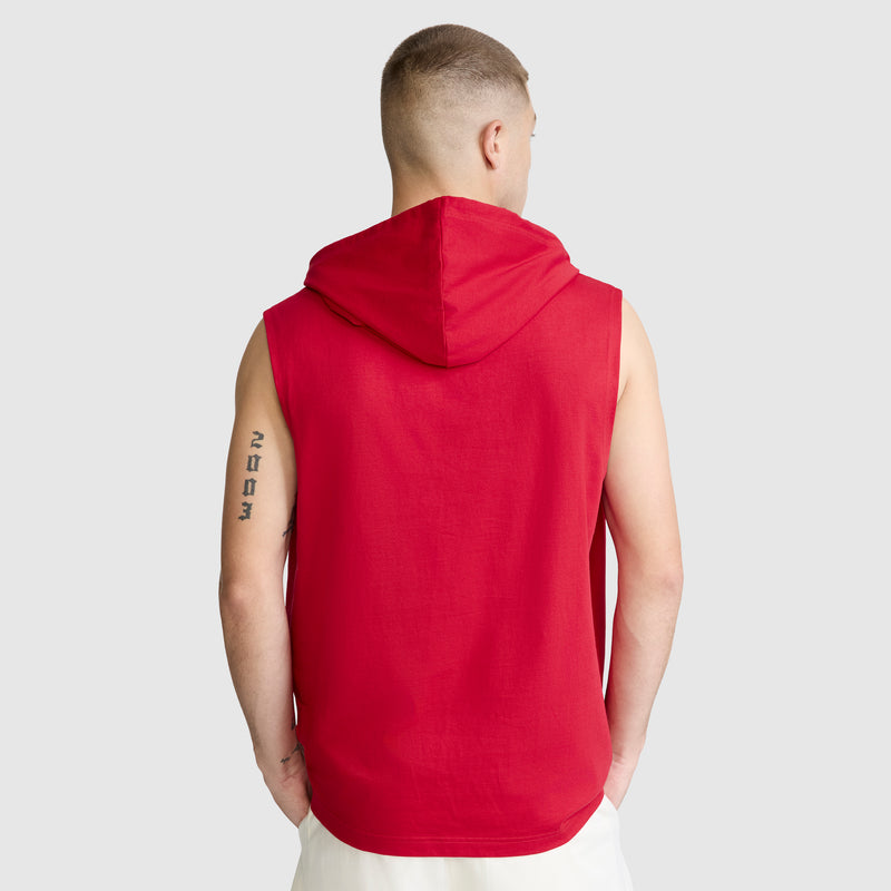 A person with short hair, seen from behind, wears a Champion Jersey Sleeveless Hoodie with the C Logo in red paired with white shorts. A tattoo is visible on their left upper arm. The background is plain light gray.