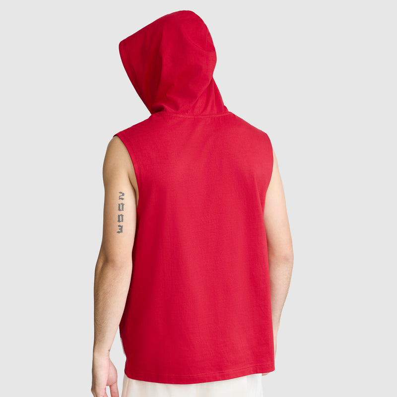 A person is seen from the back wearing a Champion Jersey Sleeveless Hoodie in red, featuring the signature C Logo and crafted from soft ring-spun cotton. The hood is up, and the individual has a vertical text tattoo on their upper left arm. The background is plain light gray.