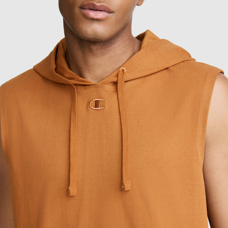 A person wearing the Champion Jersey Sleeveless Hoodie, C Logo in orange, featuring drawstrings and a small embroidered C logo near the neckline, crafted from soft ring-spun cotton, shown from the shoulders up against a plain background.