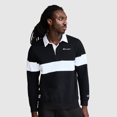 A man looks to his left against a plain gray background, sporting the Champion Striped Rugby Shirt—a black and white long sleeve rugby shirt with a white collar that highlights its classic athletic style.