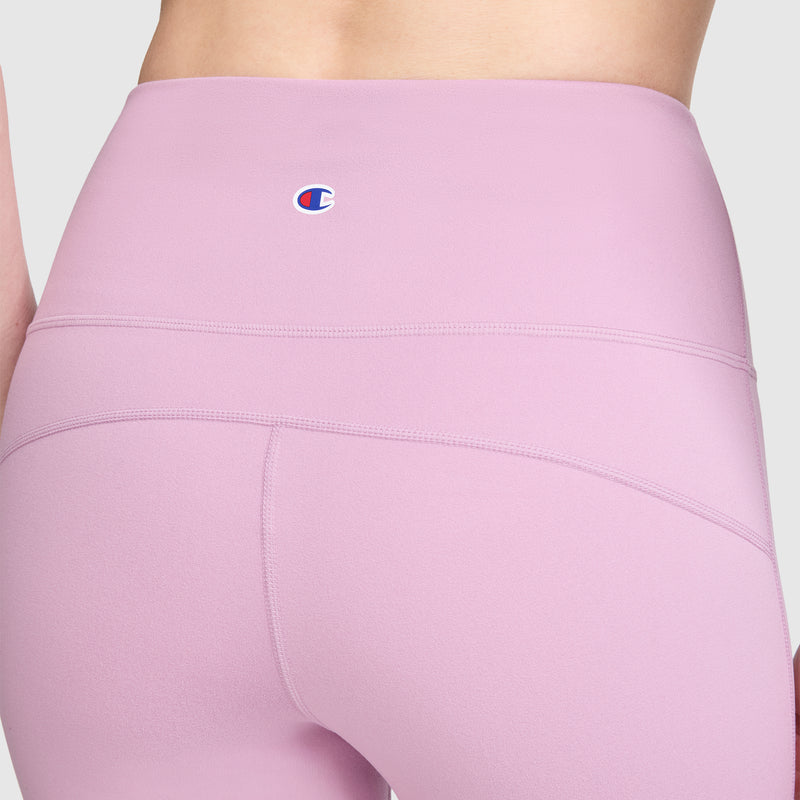 Close-up of a person wearing Champion Soft Touch Flare Leggings for women in light purple, featuring a high-waisted design with visible seam details and the signature C logo on the waistband.