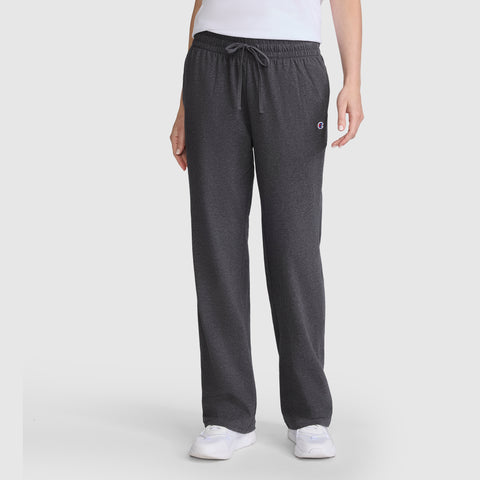 Person wearing ultra-soft, dark gray Champion Lightweight Lounge Pants, C Logo, paired with a white shirt and white sneakers, standing against a plain light background—perfect lounge pants for everyday comfort.