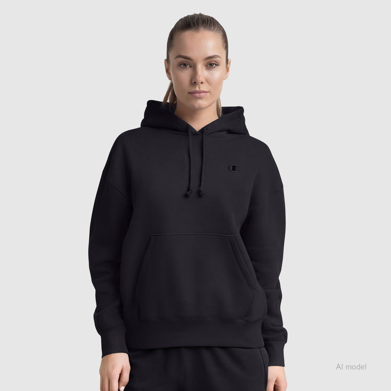 A person wears the Champion Powerblend Freshman Hoodie, C Logo, and black pants while facing forward against a light gray background. The women's hoodie features a front pocket, soft Powerblend fleece, and a small chest logo.