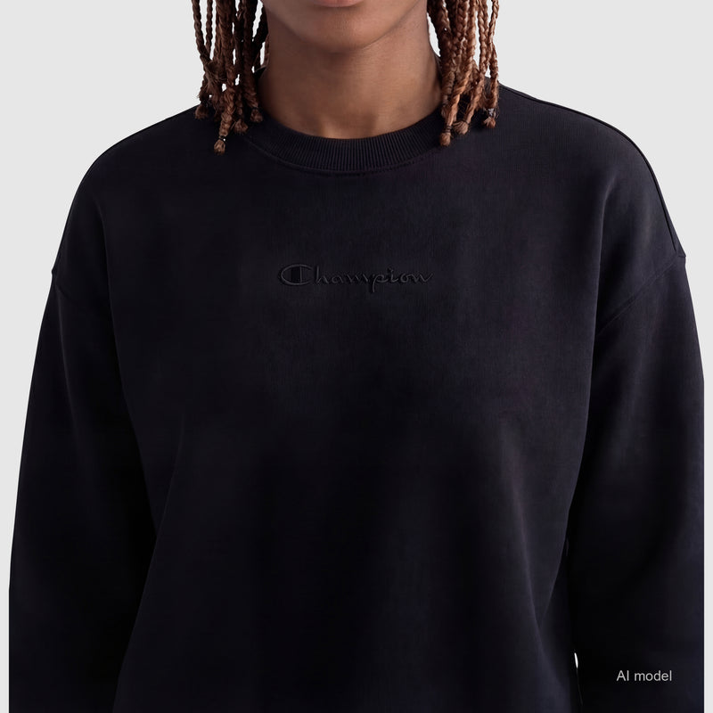 A person with medium brown skin and braided hair models the Champion Powerblend Crewneck Sweatshirt with Embroidered Script Logo in black against a light gray background. Their face is partially out of frame, with "AI model" text in the lower right corner.