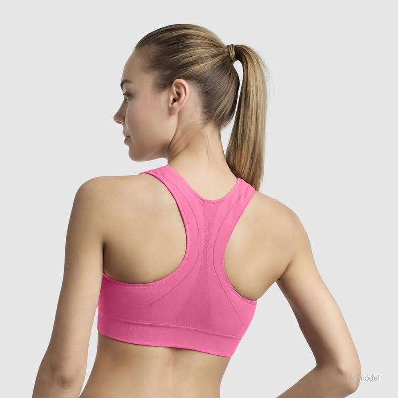 A woman with a ponytail is seen from the back wearing the Champion Seamless Racerback Sports Bra in bright pink, set against a light gray background.