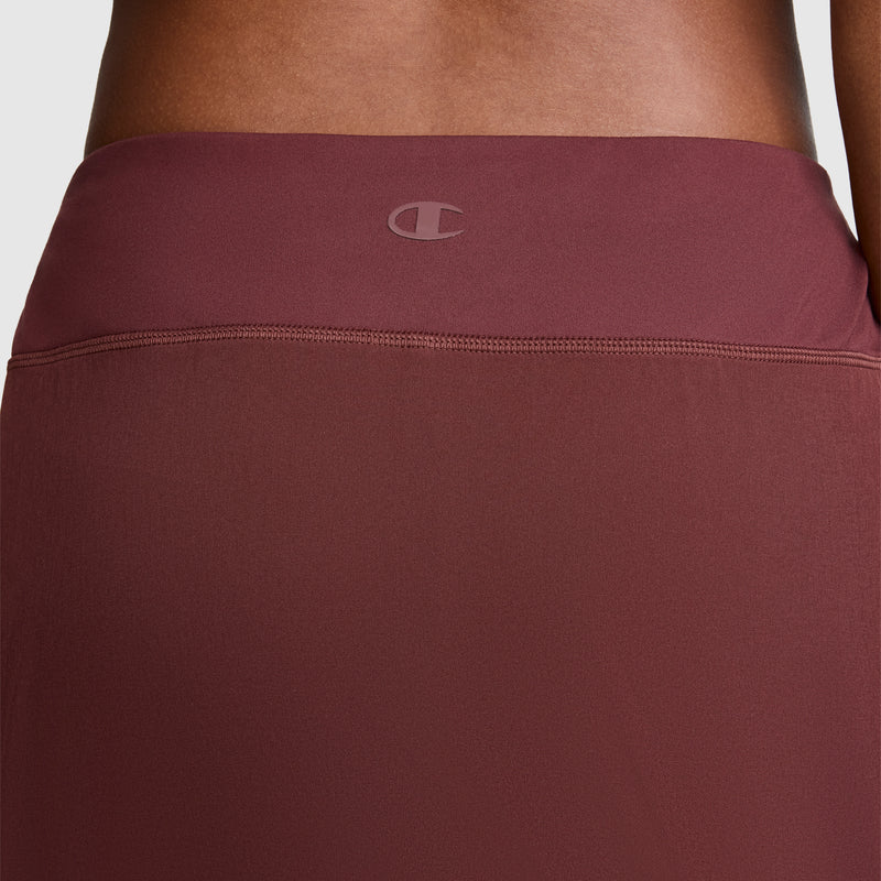 A close-up of the back waistband of the maroon Courtside Skort by Champion, featuring a subtle C logo centered near the top, highlights its sporty function for active lifestyles.
