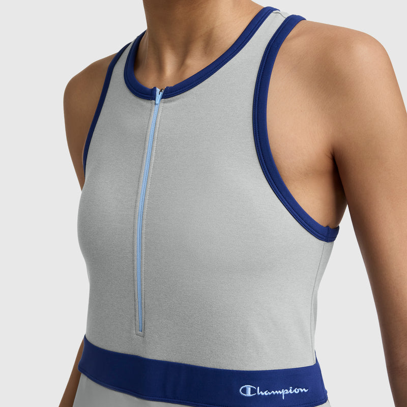 A person wearing the Champion Match Point Tennis Dress with blue trim, front zipper, and embroidered script logo. The image is cropped to show only the upper torso of this tennis dress with a built-in inner short.