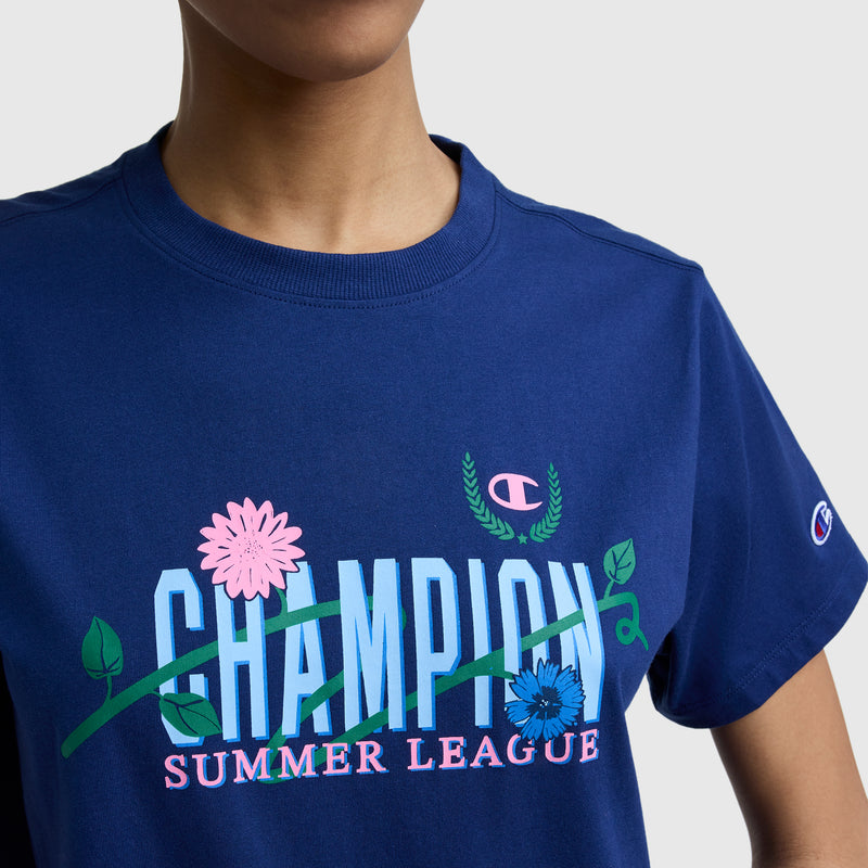 A person wearing a Champion Summer League Graphic T-Shirt, featuring the C logo and vibrant floral graphics, with only the lower face and upper torso visible.