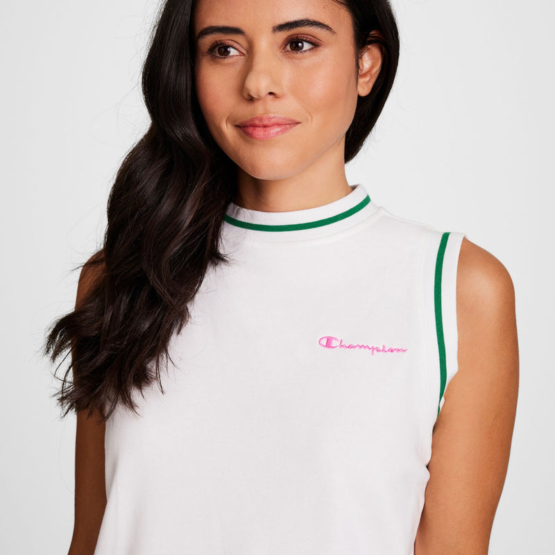 A woman with long dark hair models the Champion Country Club Sleeveless Top—standard fit, white with green trim and a pink embroidered script logo—crafted from soft French terry. She smiles softly, looking to the side against a plain white background.