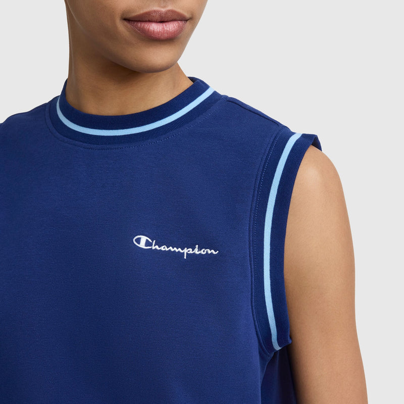 A person wears the Champion Country Club Sleeveless Top, Embroidered Script Logo, in navy with light blue and white trim. Made of soft French terry, it features an embroidered logo on the chest. Only their lower face and upper torso are visible.
