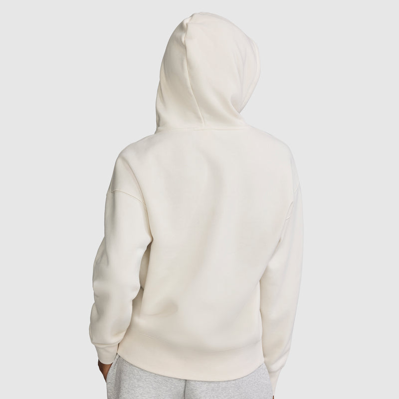 A person wearing a plain white Champion Fleece Hoodie, Satin Applique, with the hood up is viewed from the back. They are also wearing light gray pants against a light gray background.