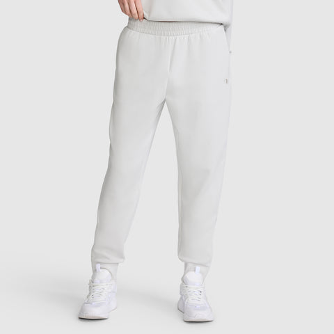 A person wearing Champion Taper Leg Jogger with Zippers in light gray, featuring a tapered jogger fit, paired with white sneakers; shown from the shoulders down against a plain background.