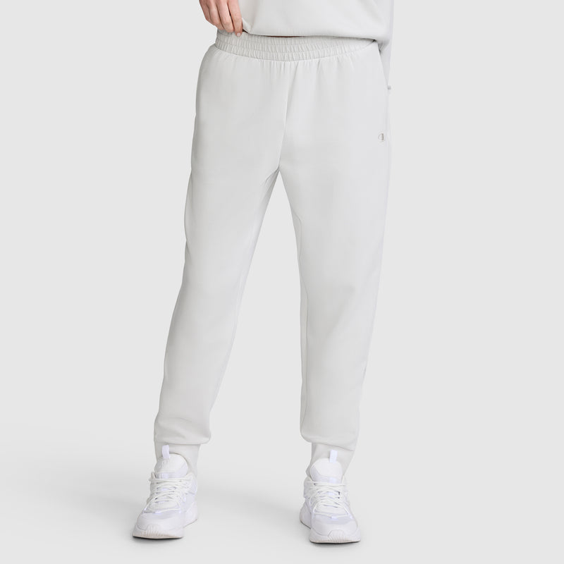 A person wearing Champion Taper Leg Jogger with Zippers in light gray, featuring a tapered jogger fit, paired with white sneakers; shown from the shoulders down against a plain background.