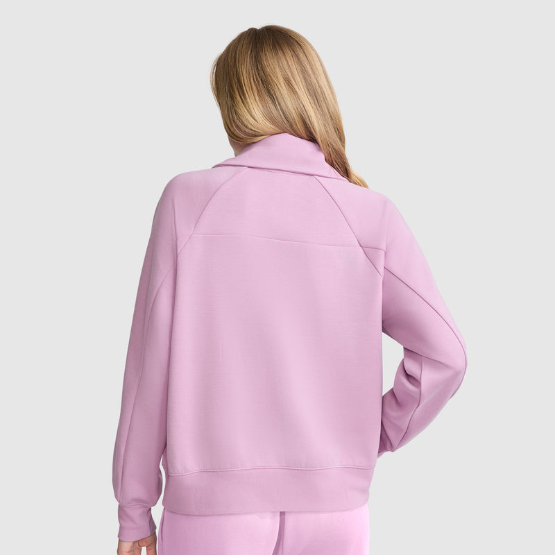 A person with long, light brown hair is shown from the back wearing a light purple Champion Quarter-Zip Pullover against a plain light gray background.