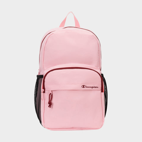The Champion Luna Backpack is a light pink minimalist bag featuring a front zip pocket, side mesh pockets, and the Champion logo stitched in burgundy thread on the front pocket. Pink zippers and a matching top handle add to its cohesive look, while an interior laptop sleeve makes it ideal for everyday use.