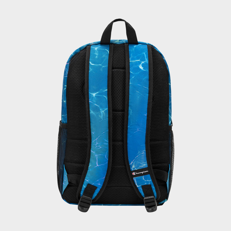 The Champion Kids' Merit Backpack has blue straps, a water ripple design, black mesh padding, adjustable straps, and side pockets. Made of durable polyester for kids, it’s shown against a light gray background.