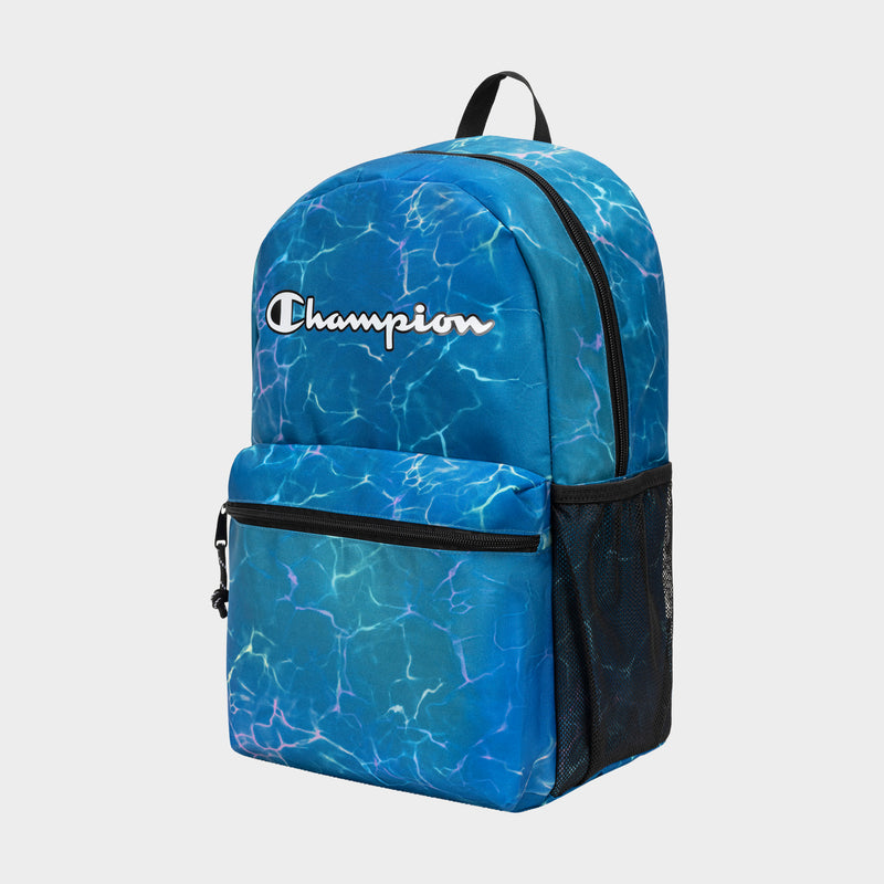 The Champion Kids' Merit Backpack features a blue water-like pattern, front zip pocket, black handle, side mesh pocket, and white Champion logo. Made of durable polyester, it’s a stylish and practical everyday backpack for kids.