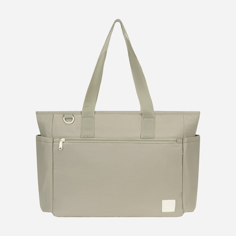 The Champion Quartz East West Tote is a light gray crinkle nylon bag with two shoulder straps, front zip pocket, side pockets, padded laptop sleeve, and a small white logo patch—ideal for travel. Shown on a plain white background.
