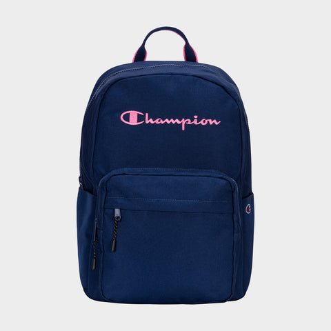 The Champion Steady Backpack is navy blue with a pink embroidered logo, front zip pocket, side pocket, top handle, and dual zipper pulls for easy main compartment access.