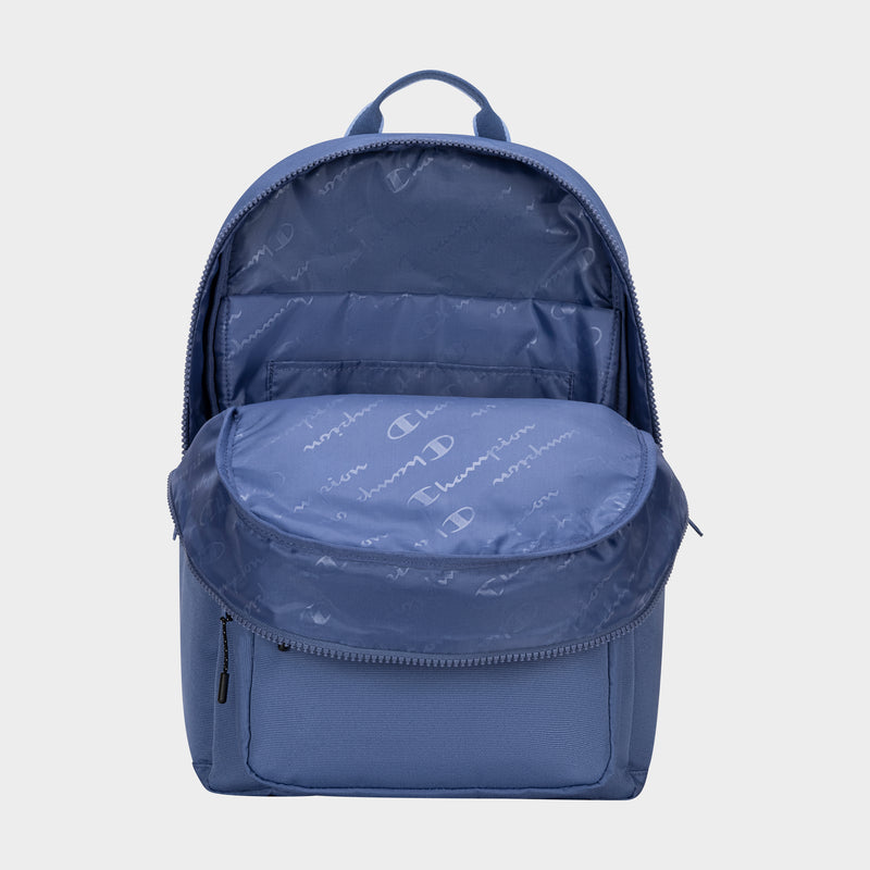 The Champion Steady Backpack in blue, shown with its main compartment open to reveal a roomy interior and inner pocket. The lining displays a repeating Champion logo pattern, making it a stylish laptop backpack against a light background.