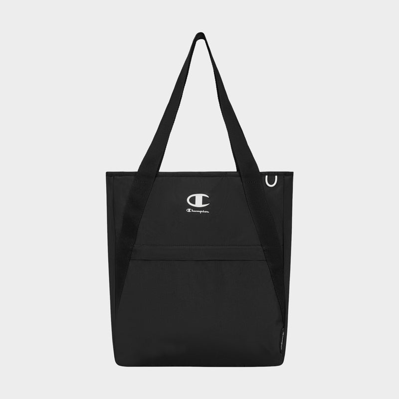 A Champion Lottie Tote in black, featuring dual handles, a front pocket, and a centrally placed white Champion logo. Made from sturdy nylon, this versatile everyday bag is showcased against a plain light gray background.