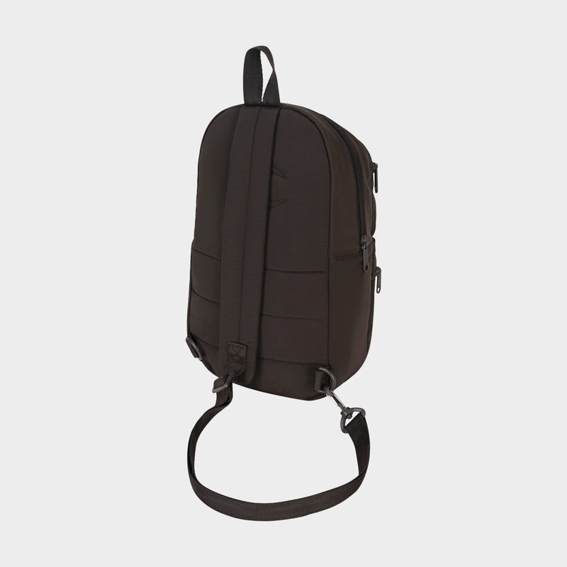 A Champion Explore Sling backpack in black, displayed from the back against a plain white background. This bag features a top handle, adjustable shoulder strap, secure zipper closures, and a sleek minimalist design—ideal for compact carrying when you want to travel light.